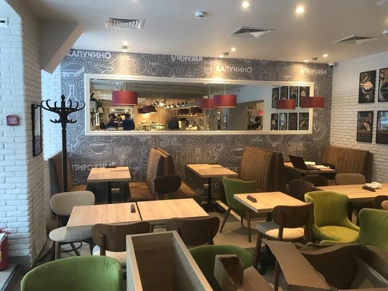 Café dining room with booth seating, mirror wall, and white brick