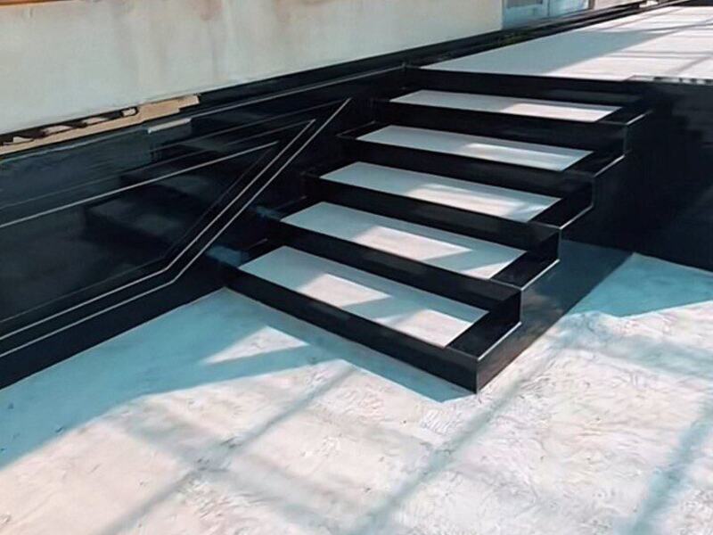 Polished black stone entry steps and base cladding