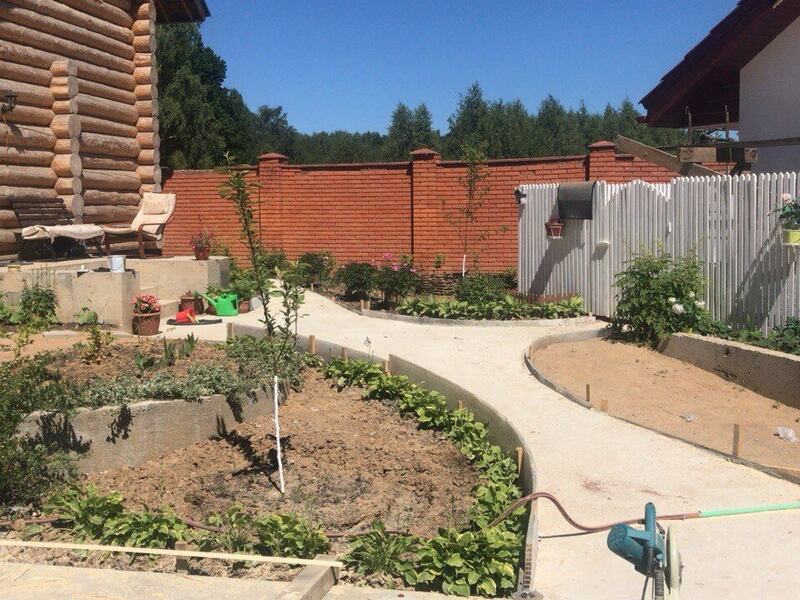 Curved concrete walkway between concrete-edged planting beds